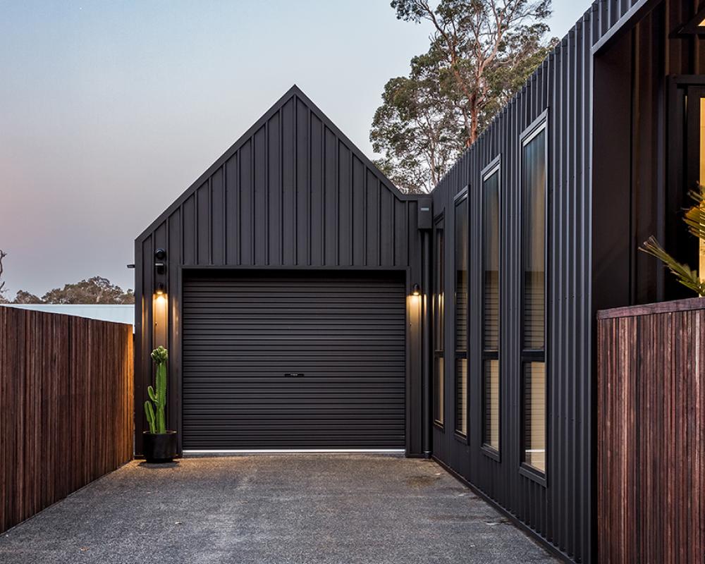 Architectural house cladding with dark vertical COLORBOND® steel and garage in steel cladding profiles. 