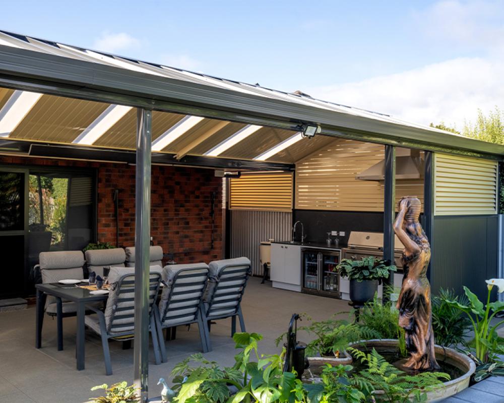 Backyard patio with mixed roof materials and outdoor kitchen, showcasing practical patio roof design with COLORBOND® steel.