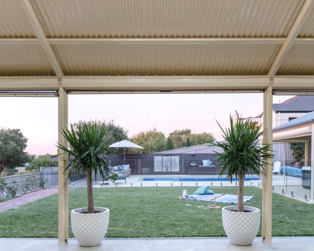 View from covered flat patio toward backyard and pool area showcasing outdoor living space