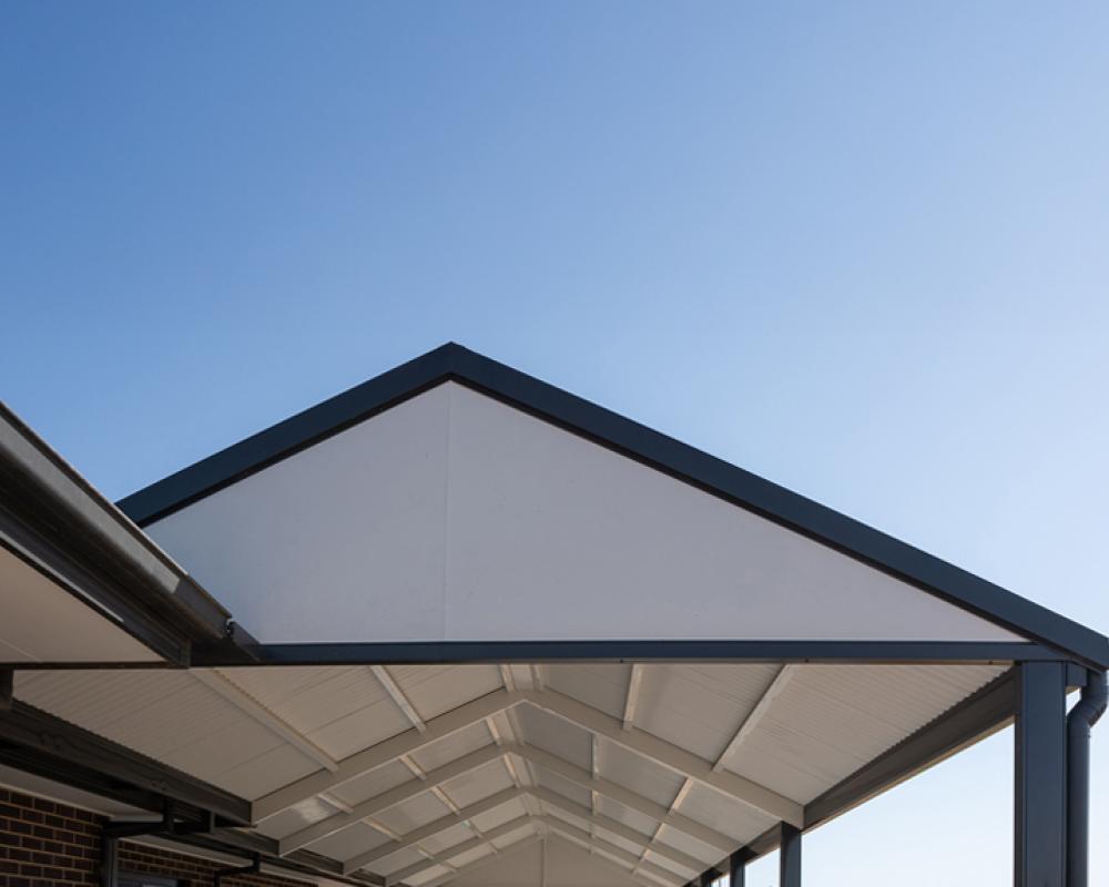 Modern COLORBOND® steel patio roof with gable design against clear blue sky