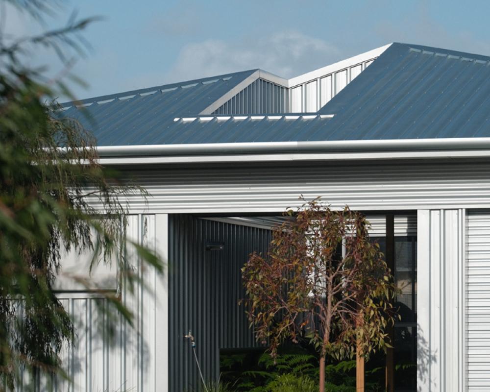 Close up of suburban home metal roof showing COLORBOND® steel sheets and distinct roofing profile types in galvanised finish