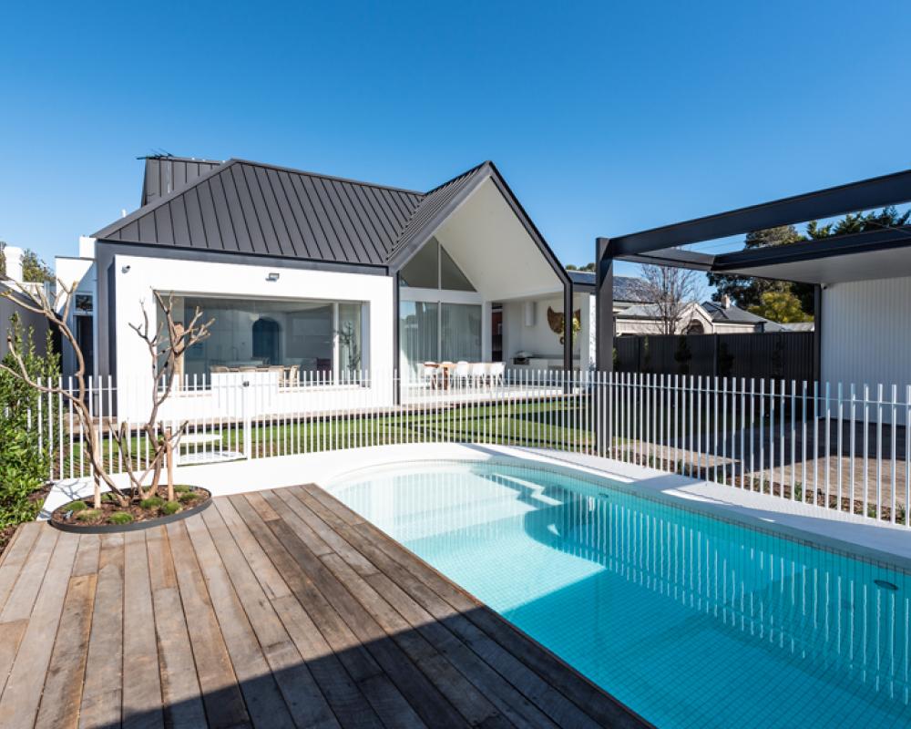 Suburban home by a pool with pitched metal roof showing distinct roof profiles and COLORBOND® steel sheets