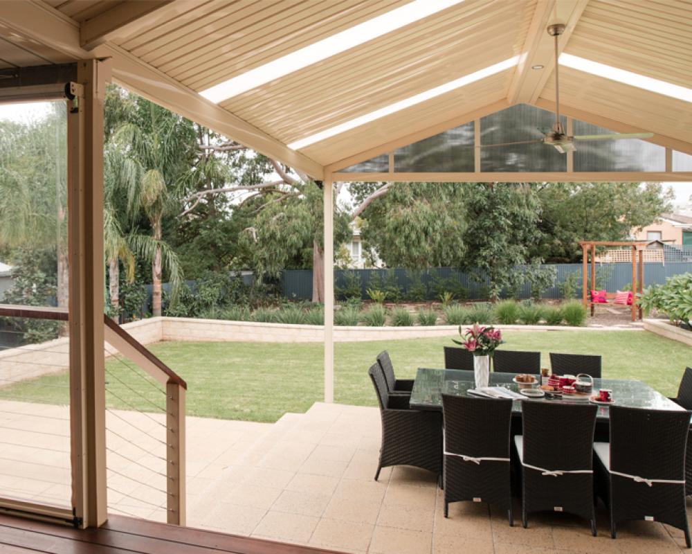 Covered patio with gabled pergola roof and outdoor dining, supporting indoor-outdoor living ideas