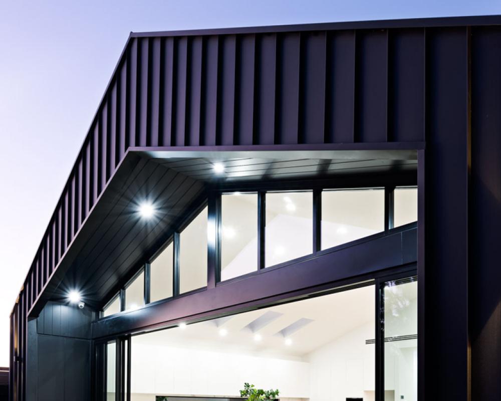 Contemporary home clad in dark Monument COLORBOND steel, showing the deeper end of the COLORBOND colours range
