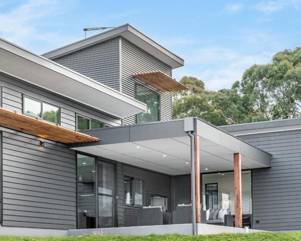 Modern home with grey COLORBOND steel wall cladding and timber detailing, showing a mid-tone from the COLORBOND colours range