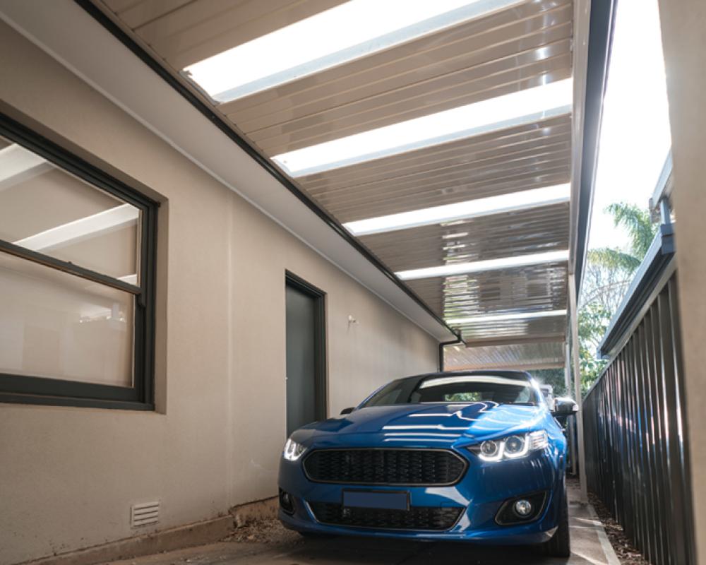 Skillion carport attached to a rendered home along a fenced side driveway, one of the more practical carport designs for narrow blocks