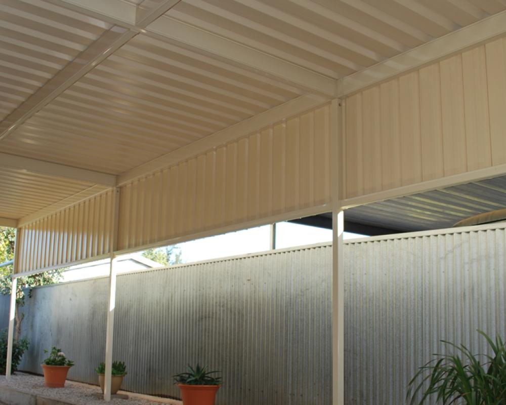 Free-standing carport with cream COLORBOND steel wall cladding and fencing, a tidy option among single carport designs