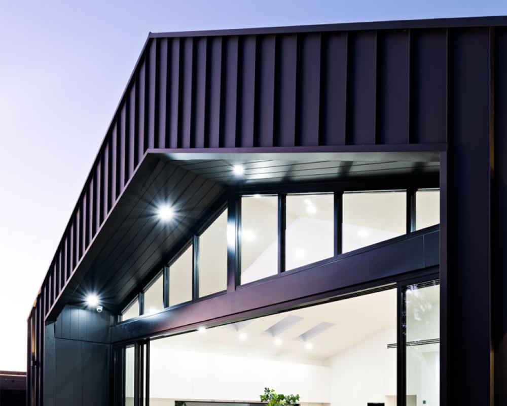 Contemporary home clad in dark Monument COLORBOND steel, showing the deeper end of the COLORBOND colours range
