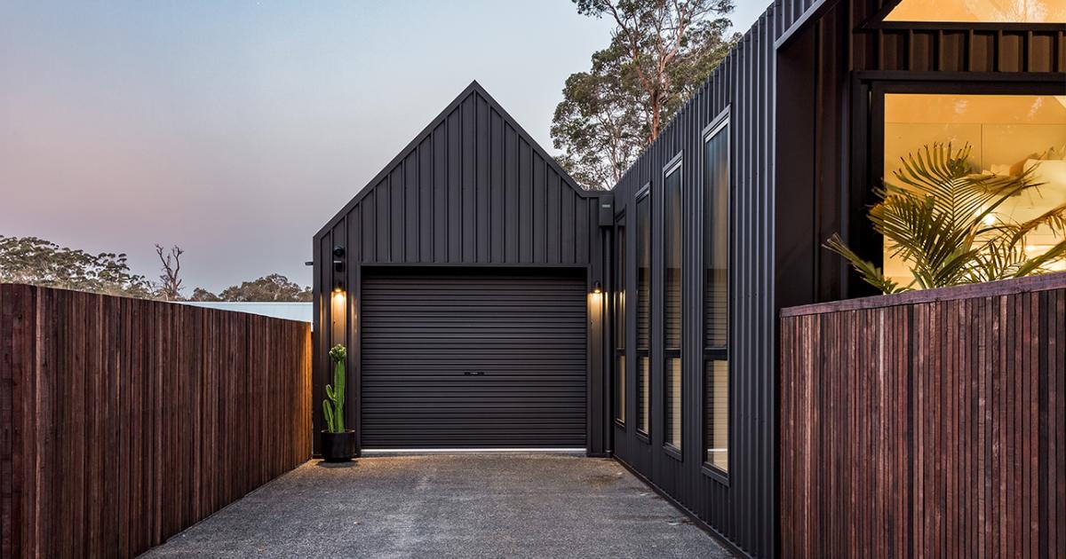 Architectural house cladding with dark vertical COLORBOND® steel and garage in steel cladding profiles. 