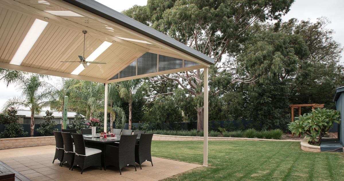 Gable patio with lined ceiling and fan, featuring outdoor dining and COLORBOND® steel roofing for backyard comfort.