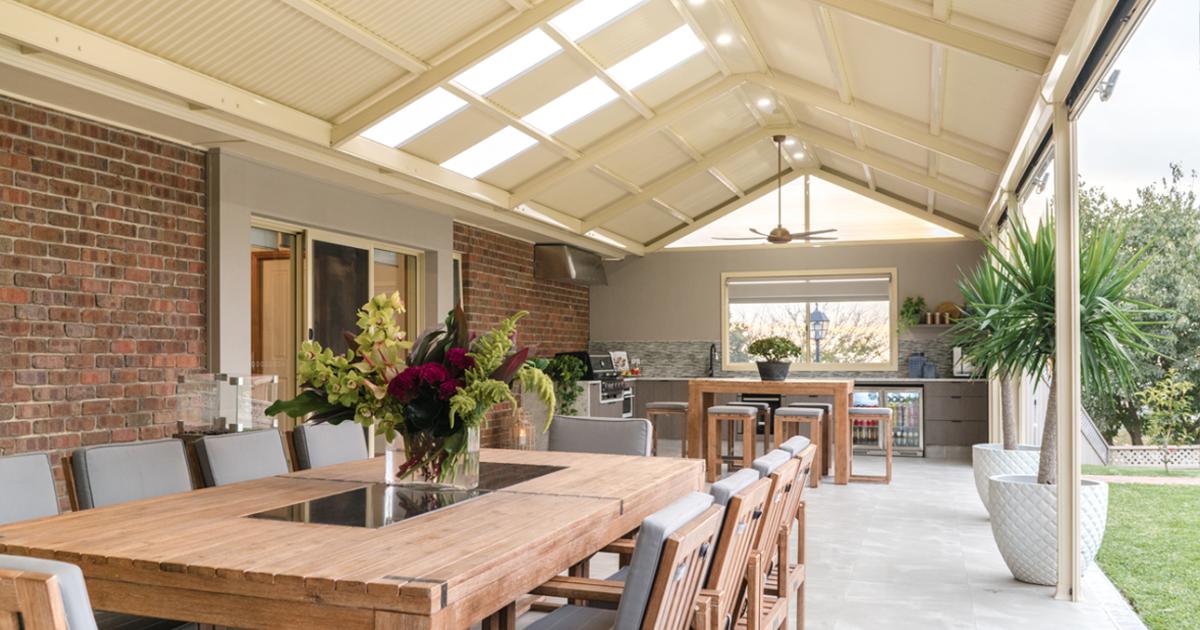 Spacious outdoor living area with timber dining set beneath a COLORBOND® steel patio roof by BlueScope