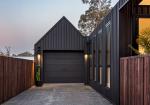 Architectural house cladding with dark vertical COLORBOND® steel and garage in steel cladding profiles. 