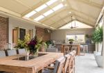 Spacious outdoor living area with timber dining set beneath a COLORBOND® steel patio roof by BlueScope