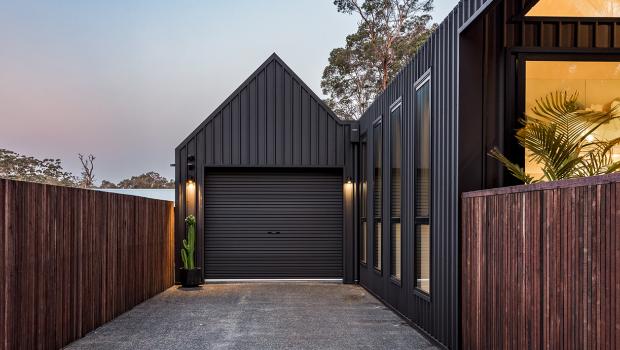 Architectural house cladding with dark vertical COLORBOND® steel and garage in steel cladding profiles. 