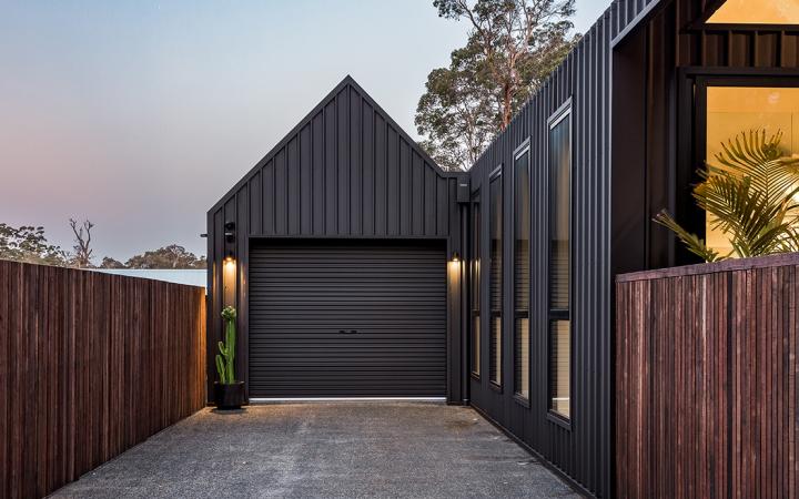 Architectural house cladding with dark vertical COLORBOND® steel and garage in steel cladding profiles. 